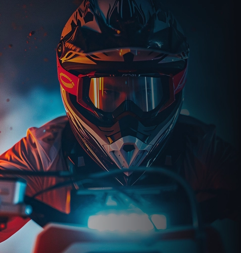 Vue de face d'un pilote de motocross portant un casque et des lunettes pendant une balade nocturne hors route.